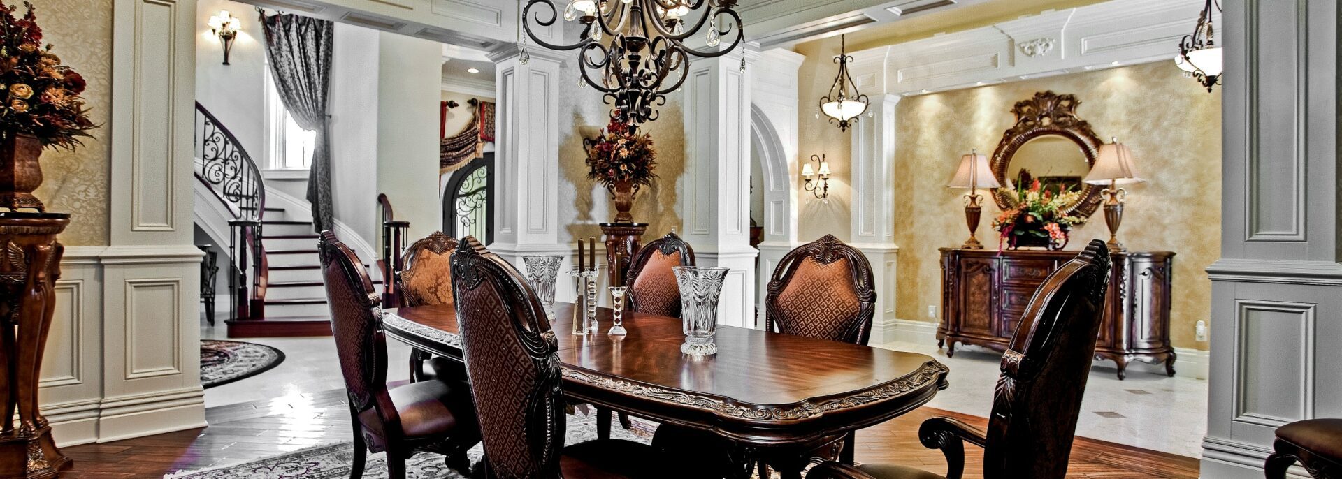A dining room table with chairs and a chandelier.