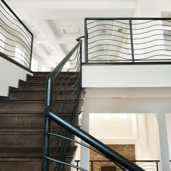 A staircase with metal railing and wood steps.